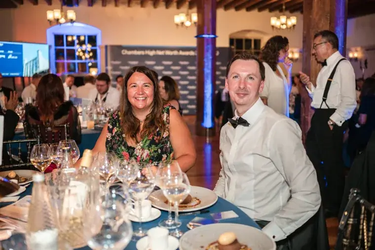 Two guests smiling together at their dinner table at the Chambers High Net Worth Awards 2025.