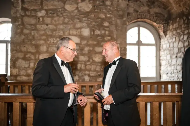 Two guests talking beside an arched window at the Chambers High Net Worth Awards 2025.
