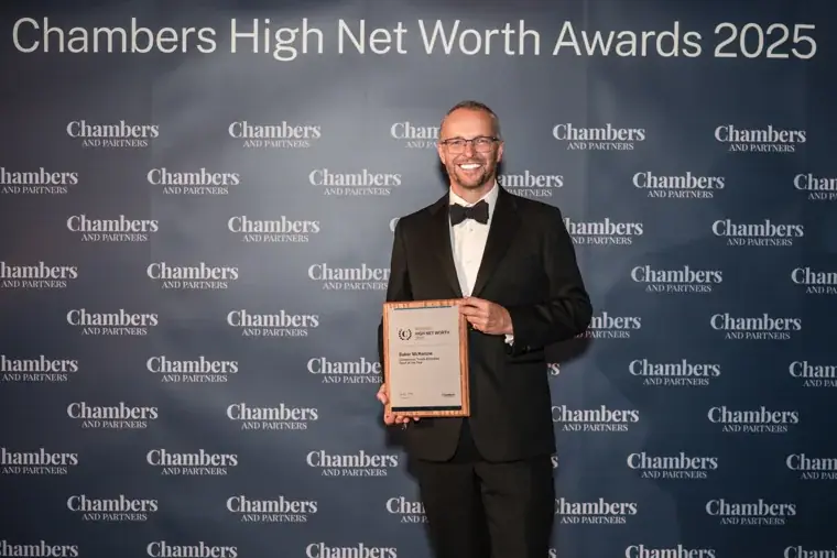 Two smiling award recipients holding a certificate at the photo wall at the Chambers High Net Worth Awards 2025.