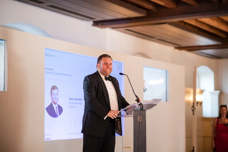 Wide view of the speaker and presentation screens at the Chambers High Net Worth Awards 2025.