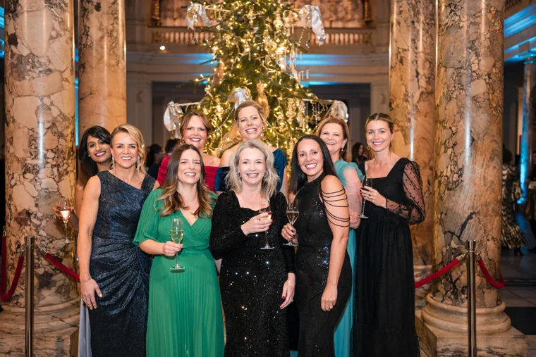 A group of women posing by the decorated tree at the Chambers UK Awards winter edition.