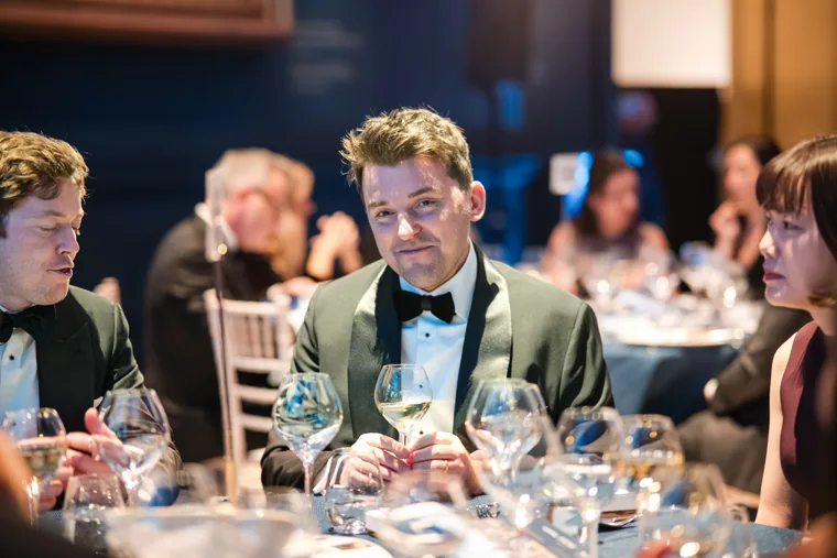 A guest smiling across the dinner table at the Chambers UK Awards winter edition.