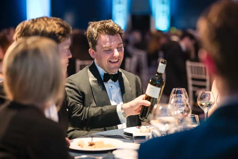 A guest smiling over dinner at the Chambers UK Awards winter edition.