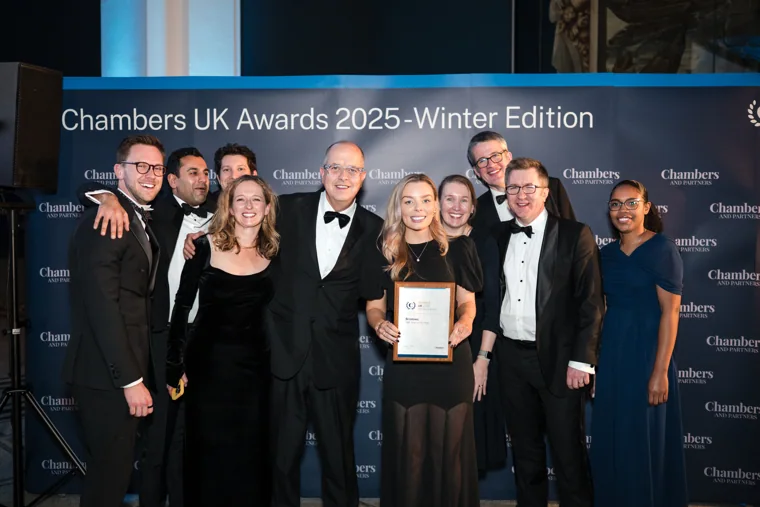 A large group celebrating with its award at the Chambers UK Awards winter edition.