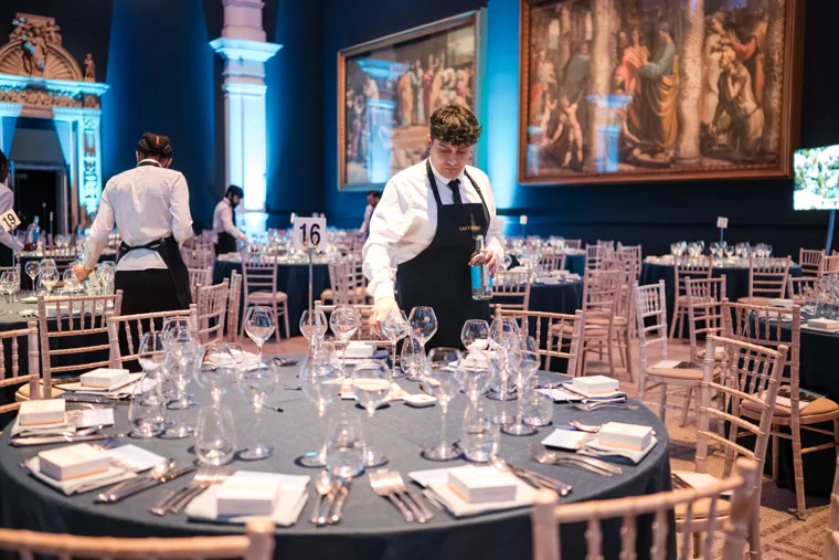 A member of staff setting a round dinner table at the Chambers UK Awards winter edition.