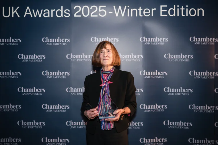 A woman holding her individual award at the Chambers UK Awards winter edition.