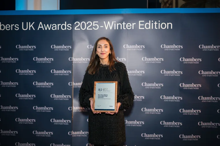 A woman posing with her award certificate at the Chambers UK Awards winter edition.