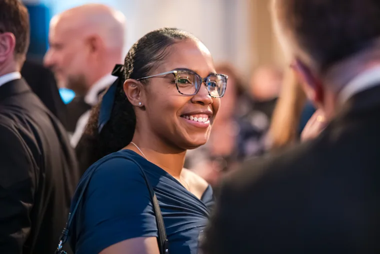 A woman smiling during a reception conversation at the Chambers UK Awards winter edition.
