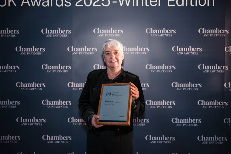An award recipient holding her framed certificate at the Chambers UK Awards winter edition.