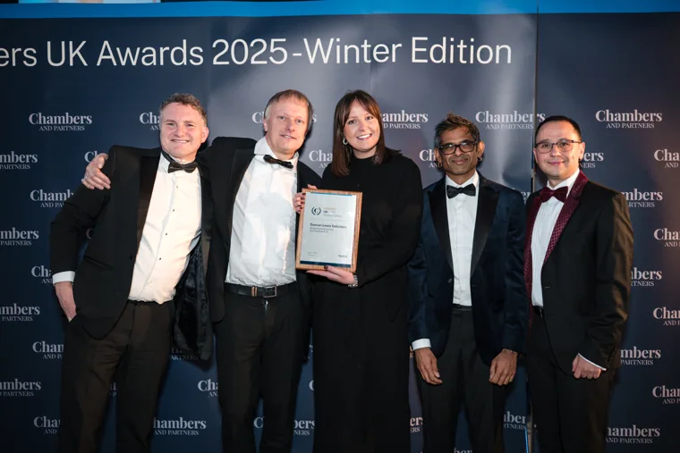 An awards team posing in formalwear at the Chambers UK Awards winter edition.