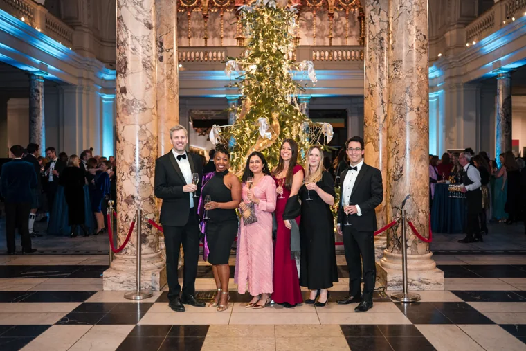 Five guests posing beneath the decorated tree at the Chambers UK Awards winter edition.
