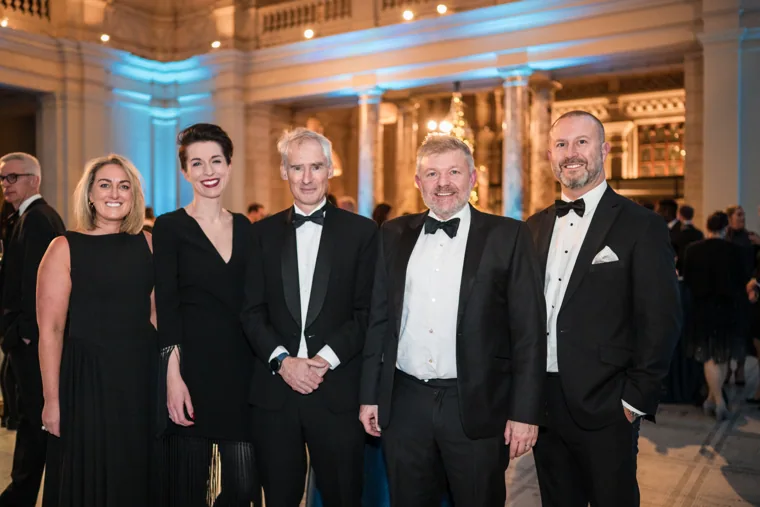 Four guests posing in evening dress at the Chambers UK Awards winter edition.