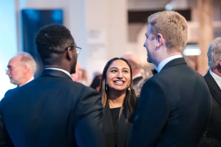 Three guests talking near the dinner tables at the Chambers UK Awards winter edition.