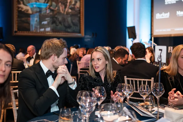 Two guests talking at their dinner table at the Chambers UK Awards winter edition.