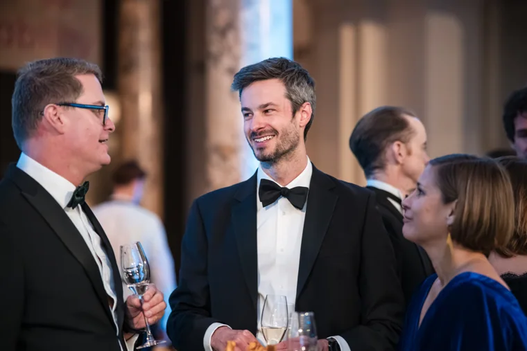 Two men chatting over drinks at the Chambers UK Awards winter edition.