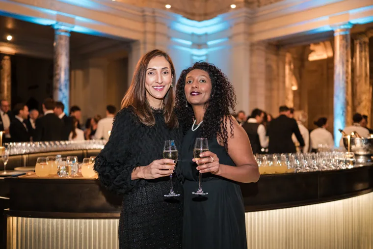 Two women smiling with drinks at the reception at the Chambers UK Awards winter edition.