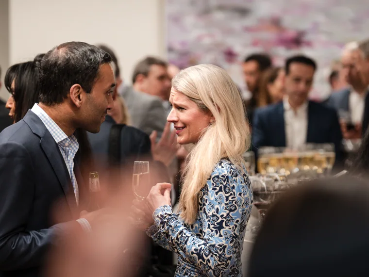 Guests sharing a laugh during a conversation at the Goodwin networking event.