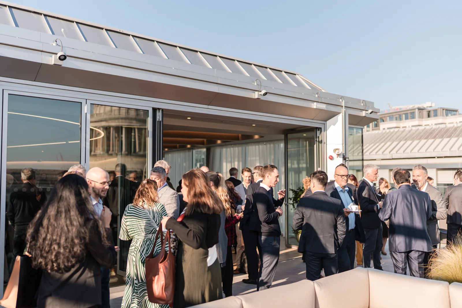 A wide view of the terrace reception at the Goodwin networking event.