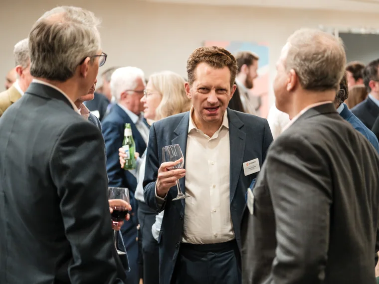 Guests smiling together during the reception at the Goodwin networking event.