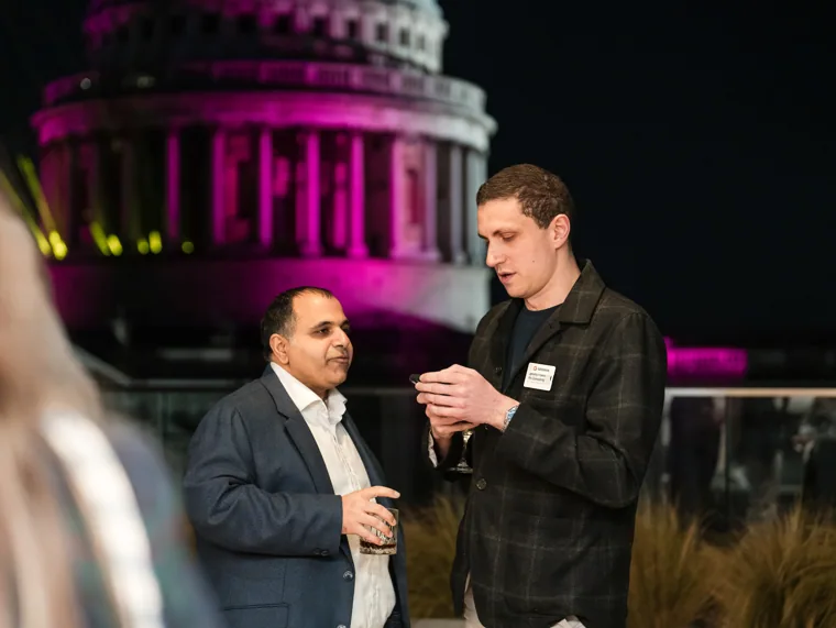 A conversation on the terrace after dark at the Goodwin networking event.