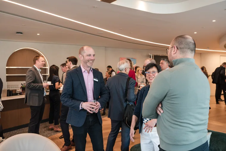 Two attendees sharing a conversation at the Goodwin networking event.