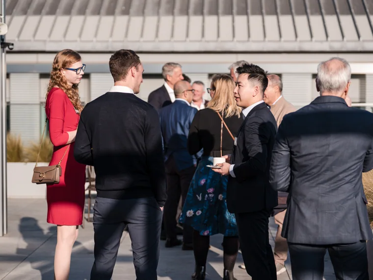 Attendees talking beside the terrace entrance at the Goodwin networking event.