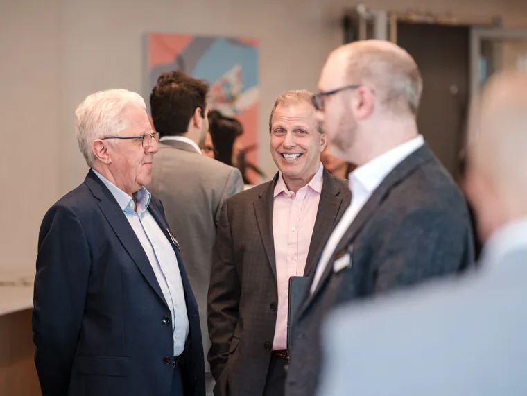 Three guests enjoying a conversation at the Goodwin networking event.