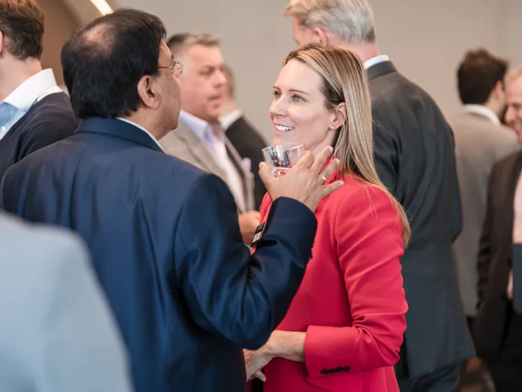 A guest making a point in the reception room at the Goodwin networking event.