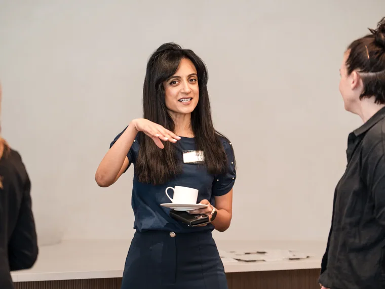 An attendee speaking during a reception conversation at the Goodwin networking event.