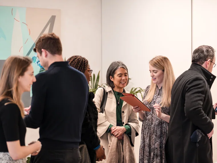 A small group chatting inside the venue at the Goodwin networking event.
