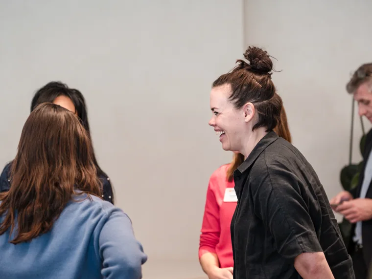 Two guests chatting as the room fills at the Goodwin networking event.
