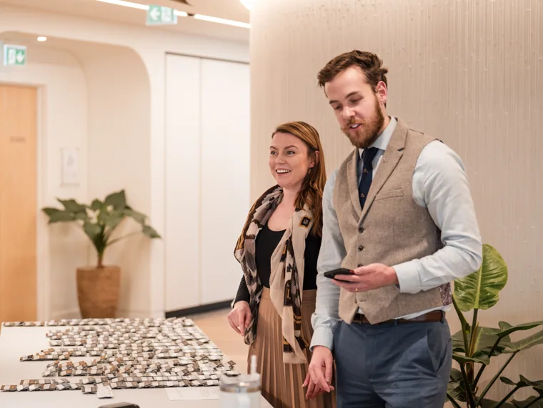 A guest standing beside the name badge table at the Goodwin networking event.