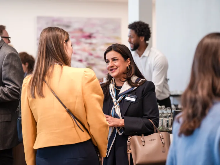 Two guests engaged in conversation at the Goodwin networking event.