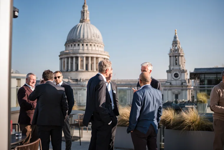 Guests talking on the terrace with St Paul’s Cathedral behind them at the Goodwin networking event.