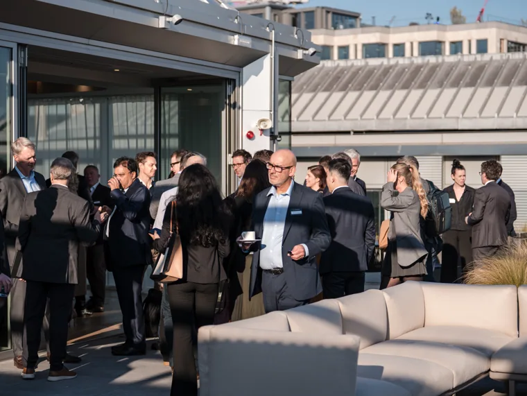 Attendees gathering on the outdoor terrace at the Goodwin networking event.