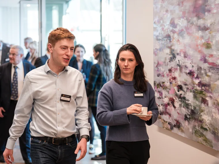 Two attendees arriving in the reception area at the Goodwin networking event.