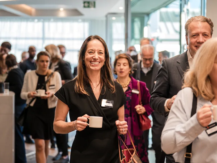 A smiling guest among the networking conversations at the Goodwin networking event.
