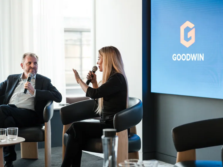 An interviewer speaking with a panel guest at the Goodwin networking event.