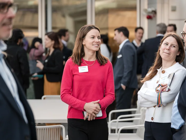 Guests pictured in conversation near the venue windows at the Goodwin networking event.