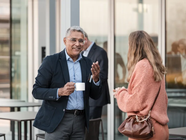 A guest smiling during a terrace conversation at the Goodwin networking event.