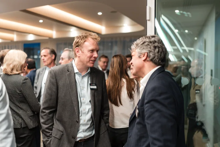 A group enjoying a conversation at the reception at the Goodwin networking event.