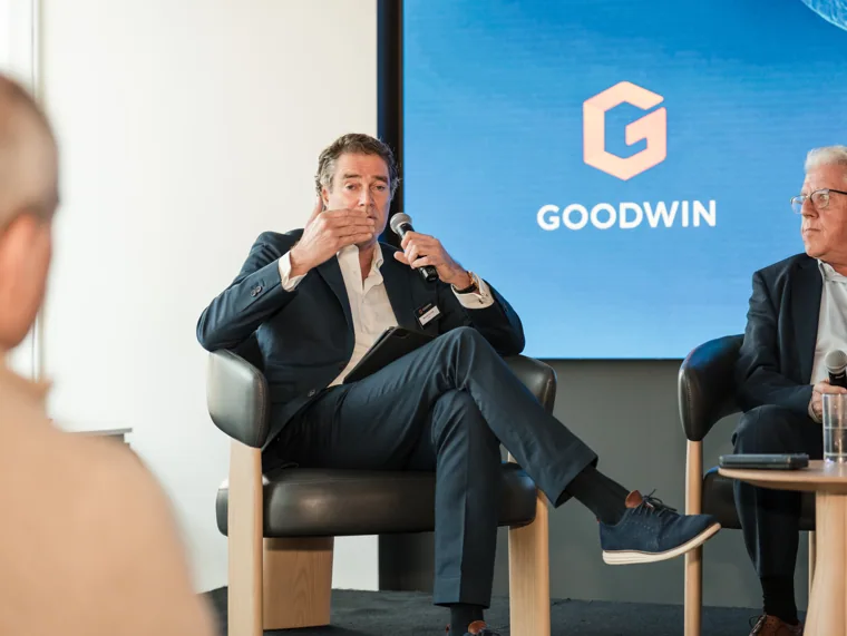 A panel guest explaining a point during the discussion at the Goodwin networking event.