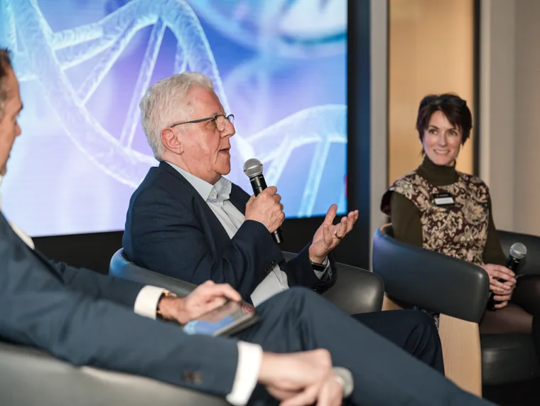 A panel guest speaking into a microphone at the Goodwin networking event.