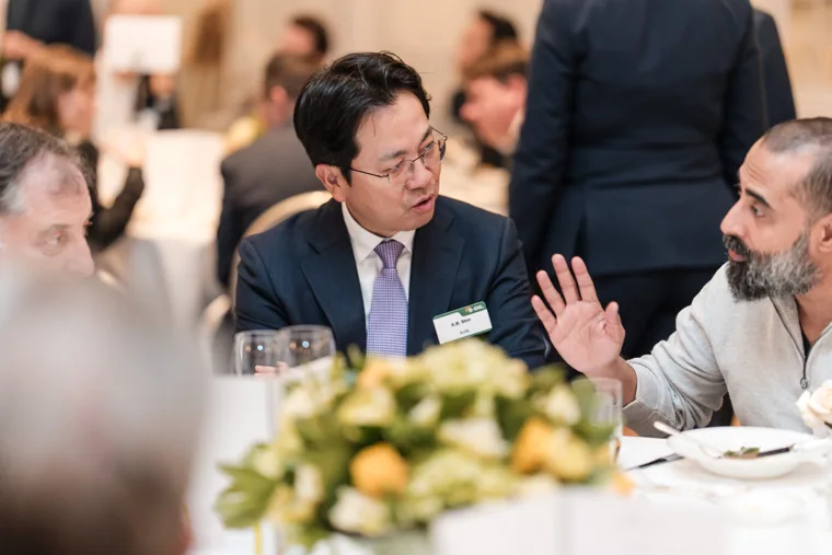 A guest gesturing while speaking at the table at the S-OIL European customer dinner.