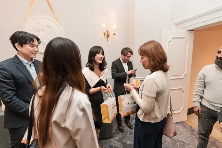 A guest receiving an S-OIL gift bag at the S-OIL European customer dinner.