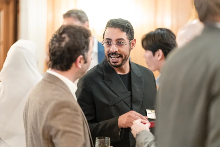 A guest smiling during a lively conversation at the S-OIL European customer dinner.