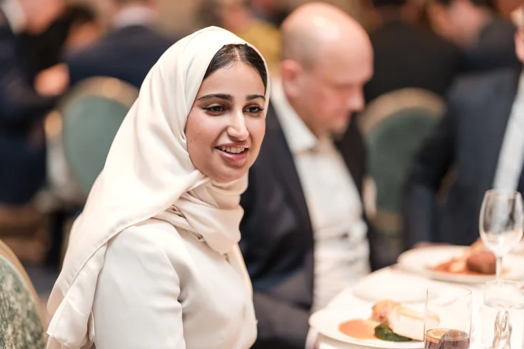 A guest smiling towards the camera at dinner at the S-OIL European customer dinner.