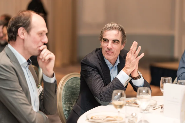 A guest speaking with his hands at dinner at the S-OIL European customer dinner.