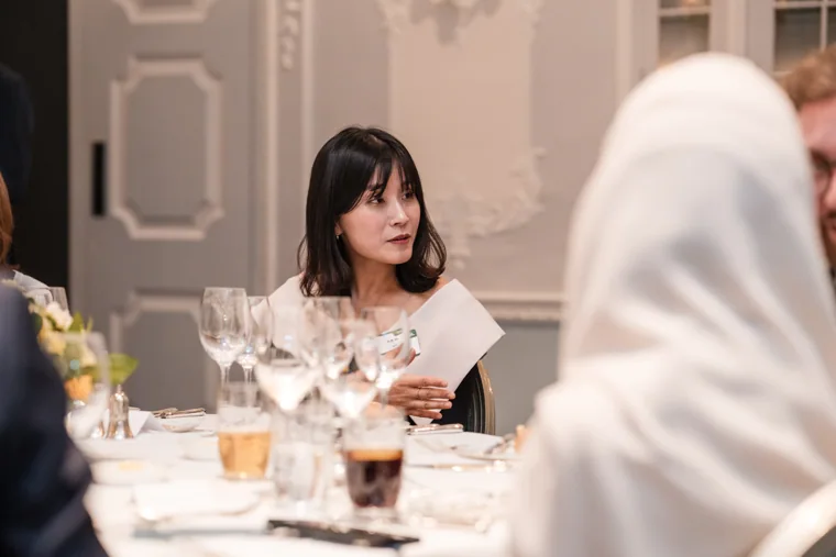 A seated guest reading the dinner menu at the S-OIL European customer dinner.