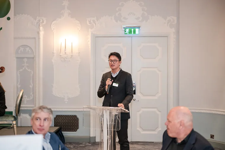 A speaker addressing guests at the lectern at the S-OIL European customer dinner.